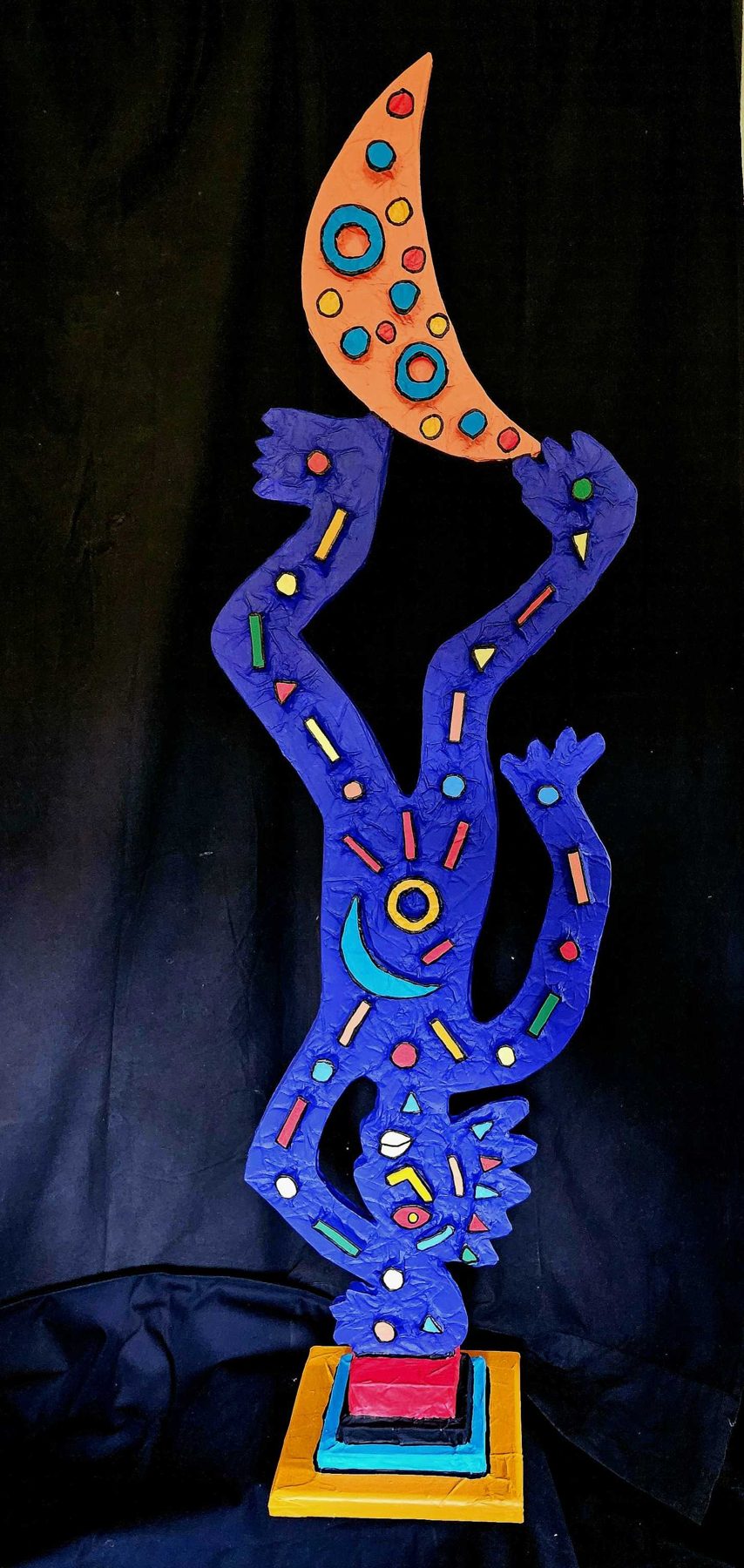 L'envers du décor : sculpture-totem bleue à la lune orange, tête en bas