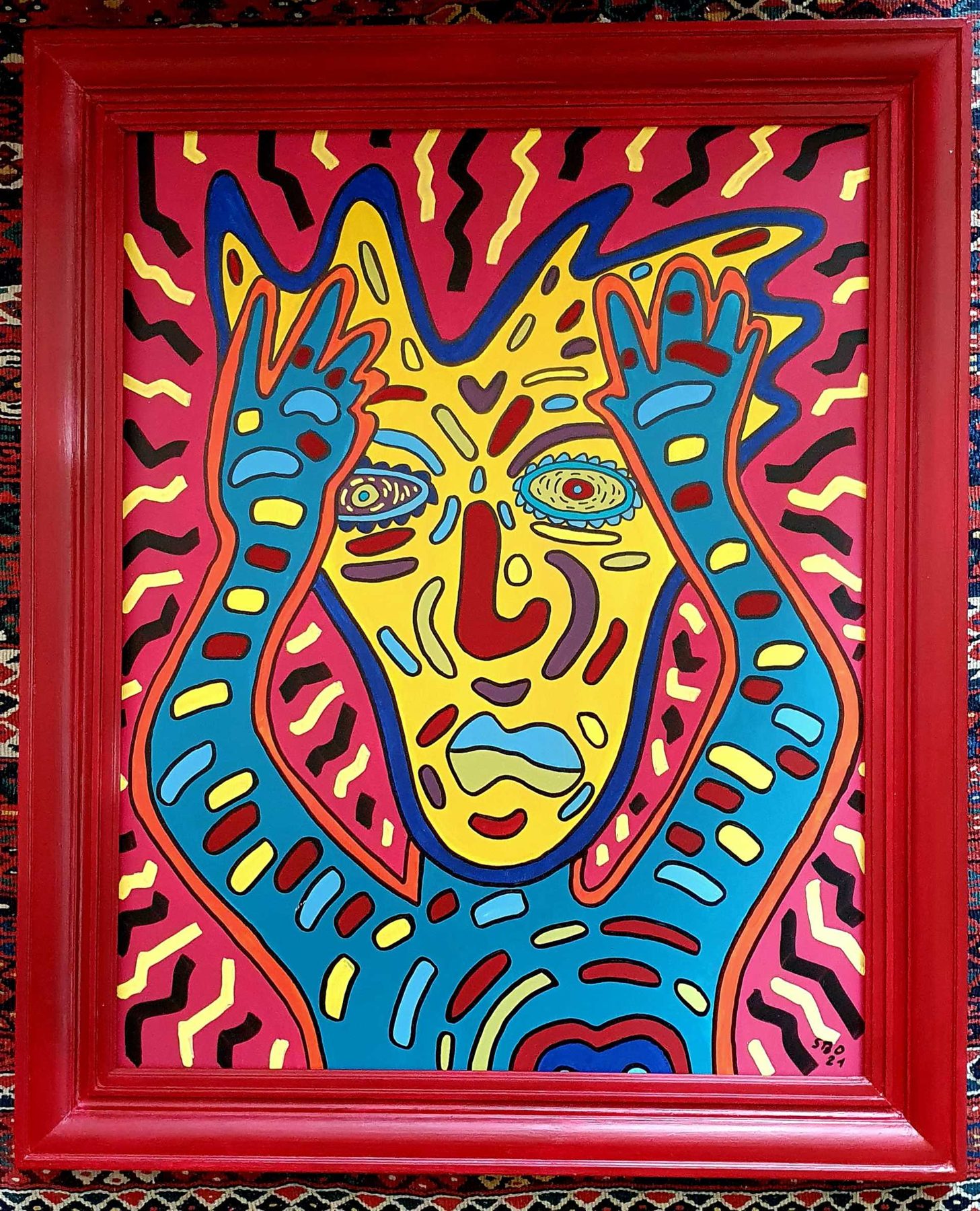 Selfie 21 : visage bleu et jaune aux mains levées, cadre rouge